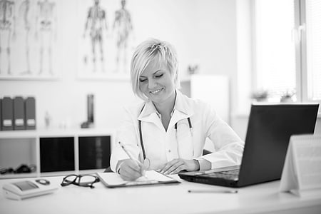 Médica tomando notas en su consulta