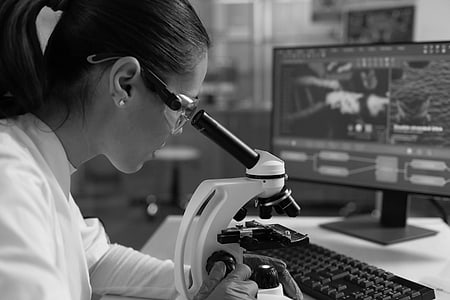 Investigadora mirando por un microscopio en el laboratorio