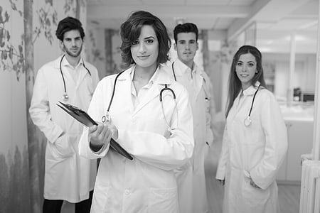 Grupo de médicos jóvenes con bata en el hospital