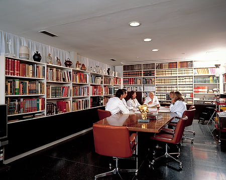 Biblioteca con médicos reunidos alrededor de una mesa