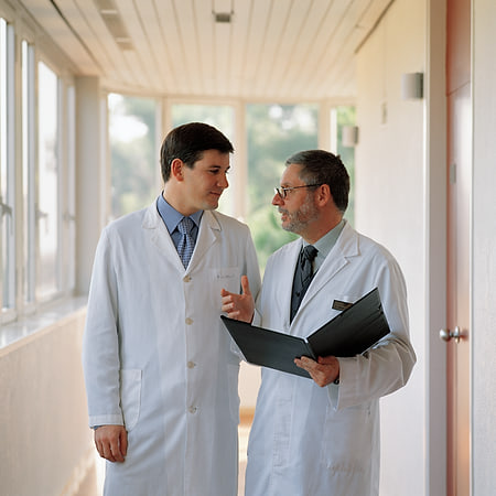 Dos médicos conversando en un pasillo de la clínica